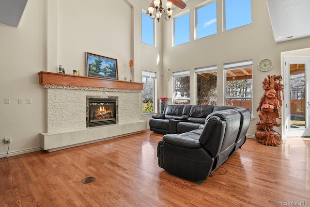 living area with plenty of natural light, a fireplace, baseboards, and wood finished floors