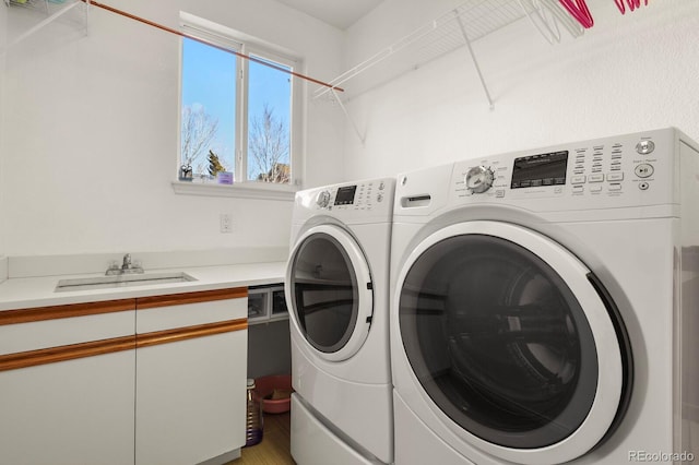 clothes washing area with a sink, laundry area, and washing machine and clothes dryer