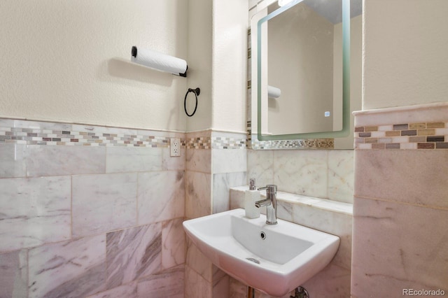 bathroom with tile walls and a sink