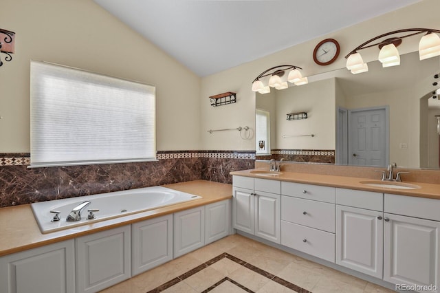 bathroom with vaulted ceiling, double vanity, a sink, and a garden tub