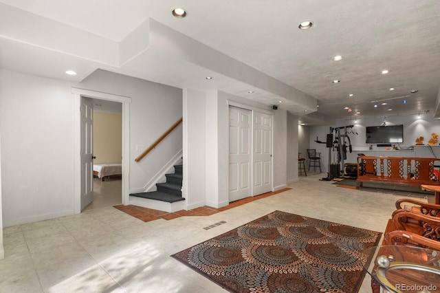 living area featuring baseboards, stairway, visible vents, and recessed lighting