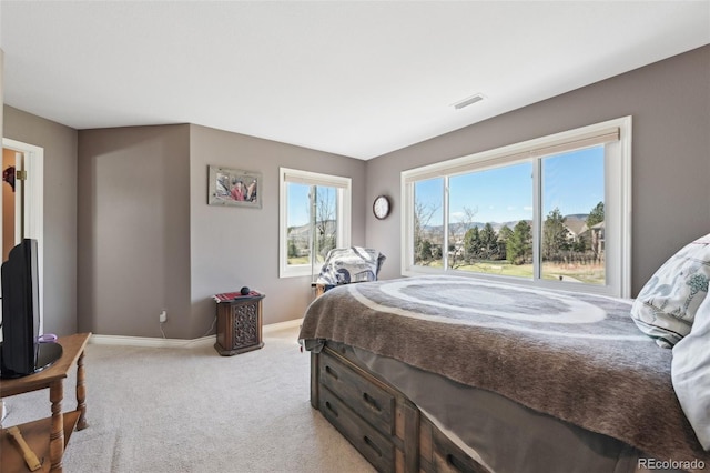 bedroom with baseboards, visible vents, and light colored carpet