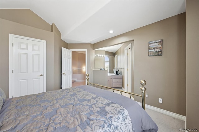 carpeted bedroom with baseboards, ensuite bath, and lofted ceiling