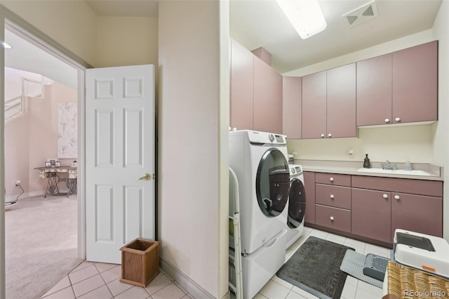laundry area featuring cabinet space, a sink, light tile patterned floors, visible vents, and washer and clothes dryer