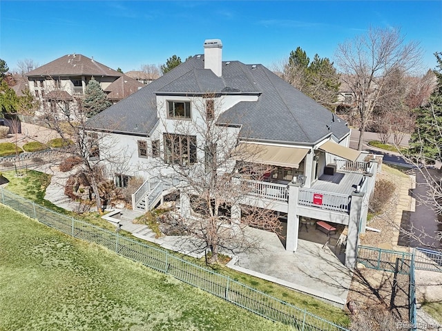 rear view of property with a patio, a chimney, a fenced backyard, and stairs