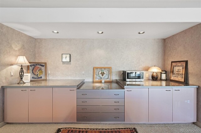 7081 Salvia St, Arvada, CO 80007 - kitchen with stainless steel microwave, stainless steel countertops, recessed lighting, and light colored carpet