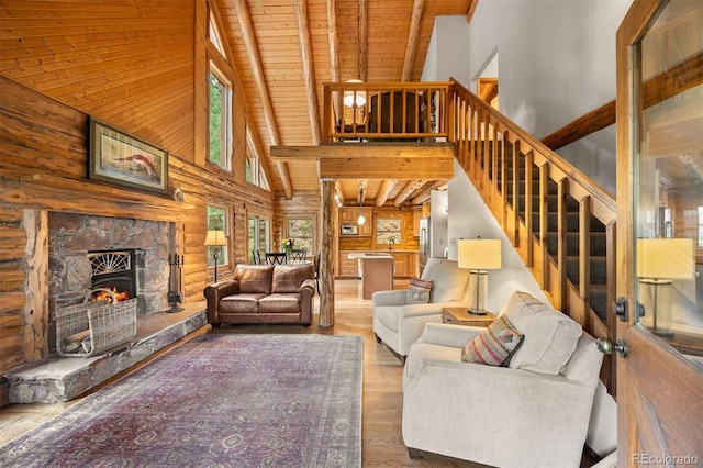 80 Spruce Ct, Evergreen, CO 80439 - living area with high vaulted ceiling, a wooden ceiling with exposed beams, stairway, wood finished floors, and a stone fireplace