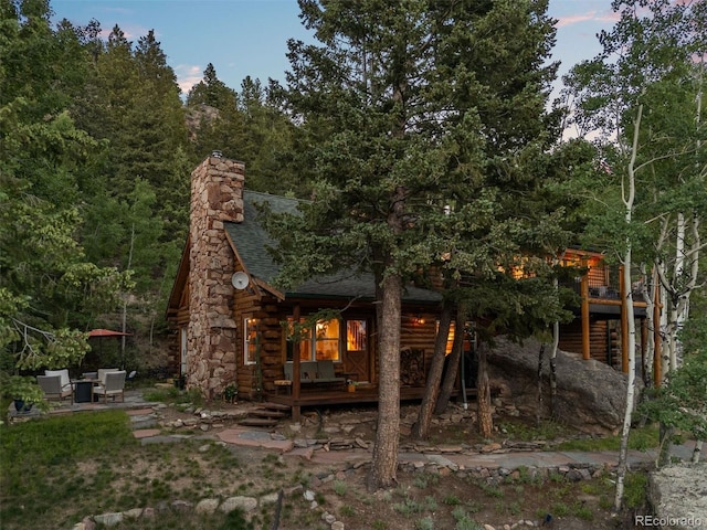 80 Spruce Ct, Evergreen, CO 80439 - back of property featuring a shingled roof, log siding, a deck, and a chimney