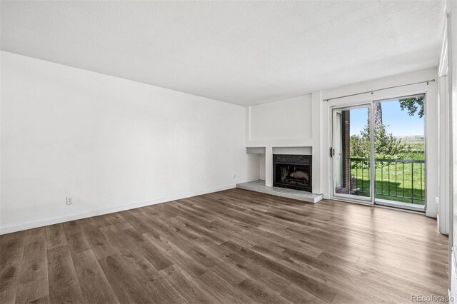 4899 S Dudley St Unit 7E, Littleton, CO 80123 - unfurnished living room featuring a fireplace with raised hearth and wood finished floors