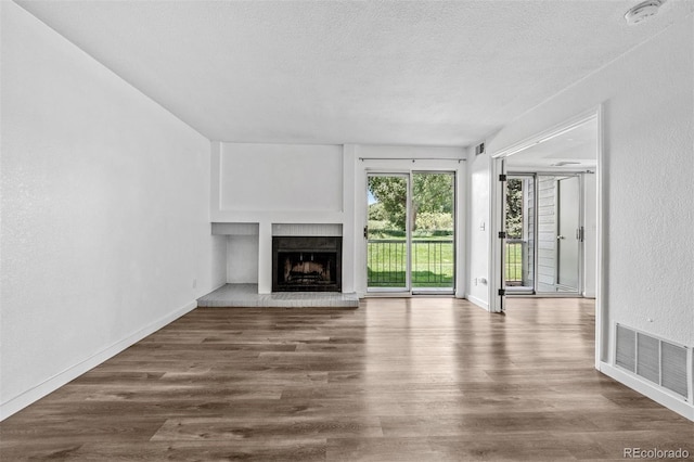 4899 S Dudley St Unit 7E, Littleton, CO 80123 - unfurnished living room featuring a fireplace, wood finished floors, and a textured ceiling