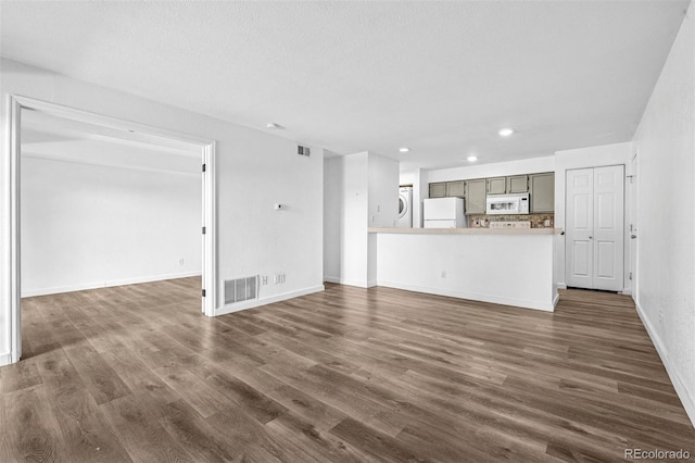 4899 S Dudley St Unit 7E, Littleton, CO 80123 - unfurnished living room with dark wood finished floors, recessed lighting, and stacked washer and clothes dryer