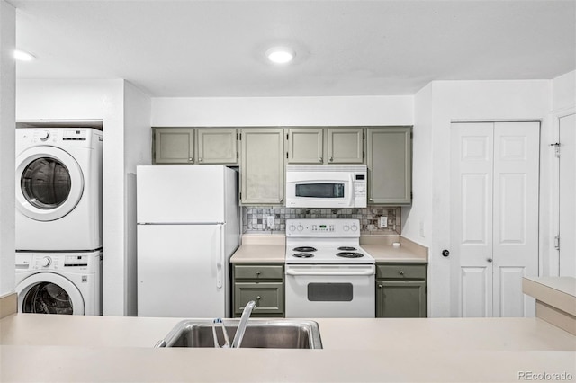 4899 S Dudley St Unit 7E, Littleton, CO 80123 - kitchen featuring white appliances, stacked washer and clothes dryer, decorative backsplash, and light countertops