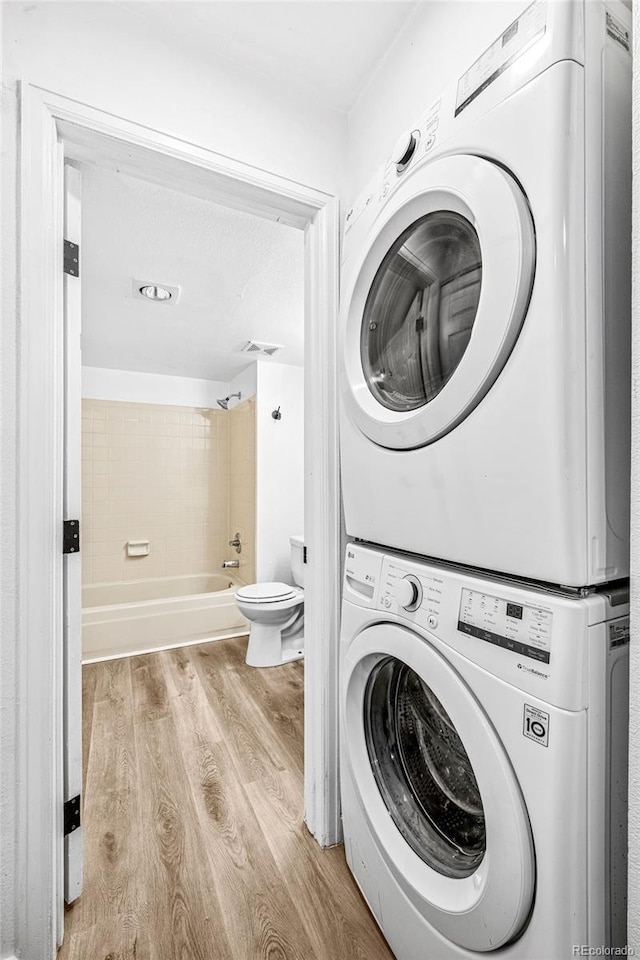 4899 S Dudley St Unit 7E, Littleton, CO 80123 - laundry room featuring stacked washer / drying machine and wood finished floors