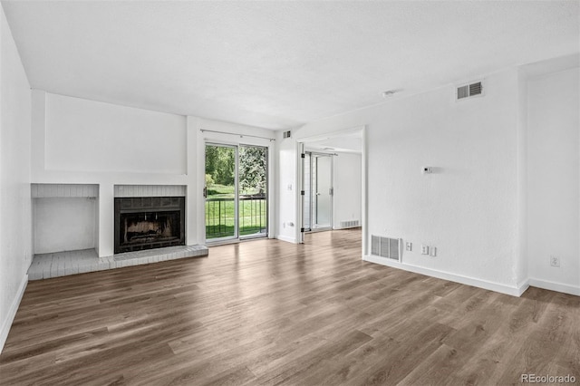 4899 S Dudley St Unit 7E, Littleton, CO 80123 - unfurnished living room with wood finished floors and a fireplace with raised hearth
