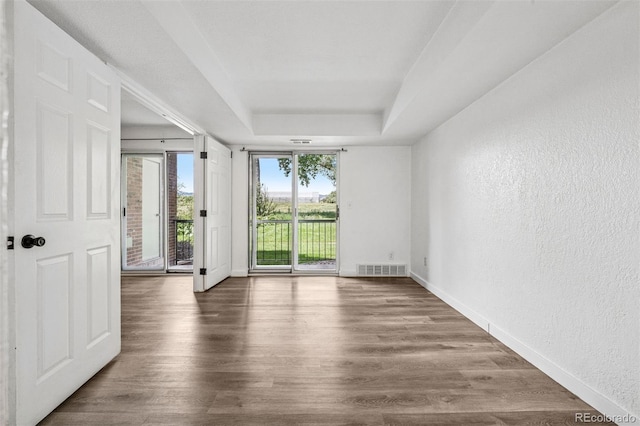 4899 S Dudley St Unit 7E, Littleton, CO 80123 - unfurnished room featuring a tray ceiling, a textured wall, and wood finished floors