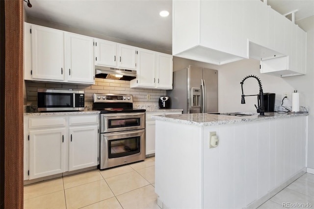 kitchen with under cabinet range hood, stainless steel appliances, white cabinetry, and light tile patterned flooring