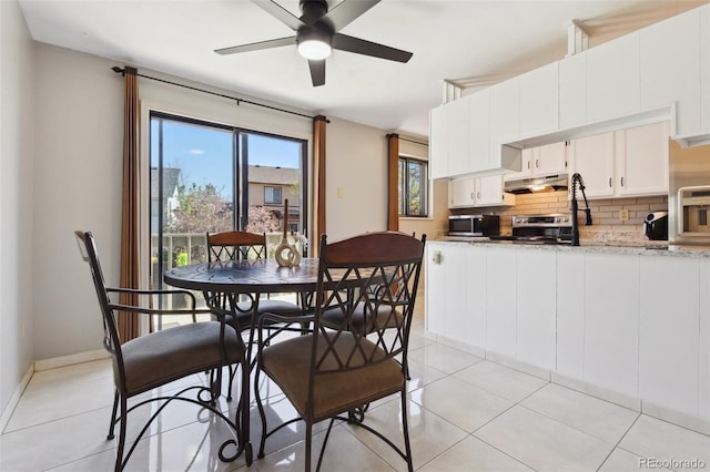 dining space with baseboards, a ceiling fan, and light tile patterned floors