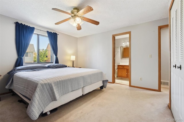 bedroom featuring connected bathroom, a ceiling fan, a closet, baseboards, and light carpet