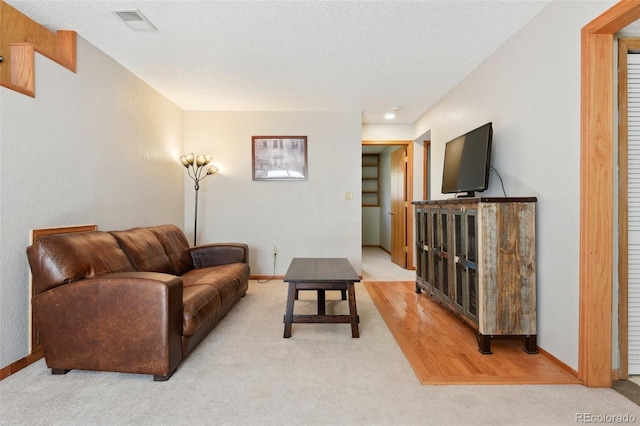 living room featuring carpet flooring, baseboards, and visible vents