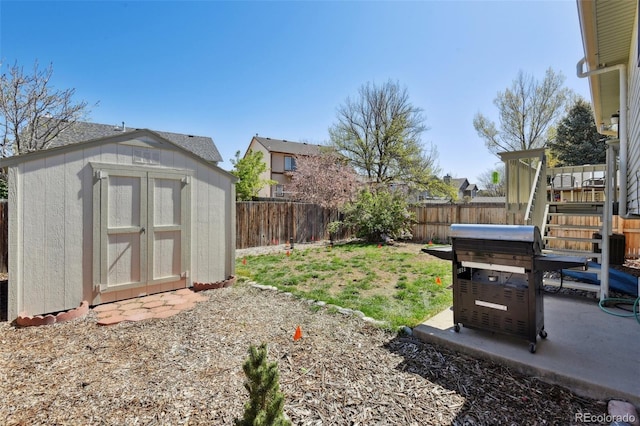 view of yard featuring an outdoor structure, a shed, a fenced backyard, and a patio