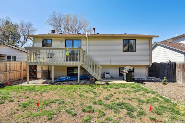 rear view of property with a fenced backyard, stairs, a wooden deck, and central AC unit