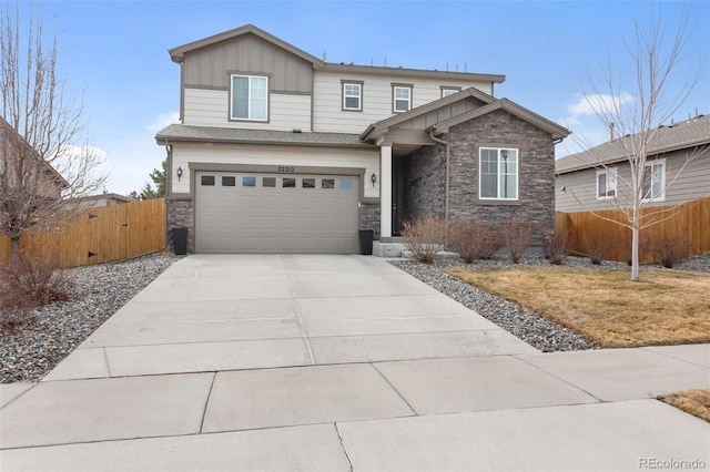 view of front of home featuring concrete driveway, board and batten siding, fence, a garage, and stone siding