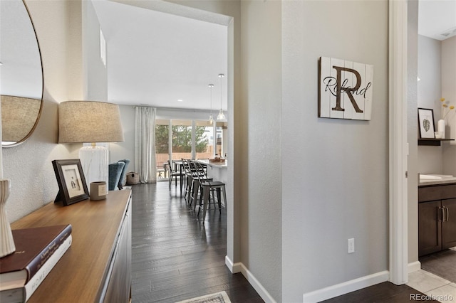 hallway featuring dark wood-style floors and baseboards