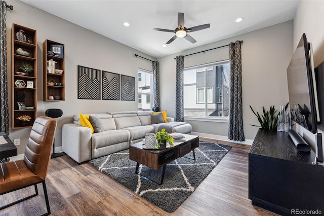 living room with wood-type flooring and ceiling fan