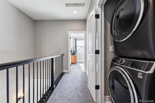 laundry area featuring stacked washer and dryer and carpet flooring