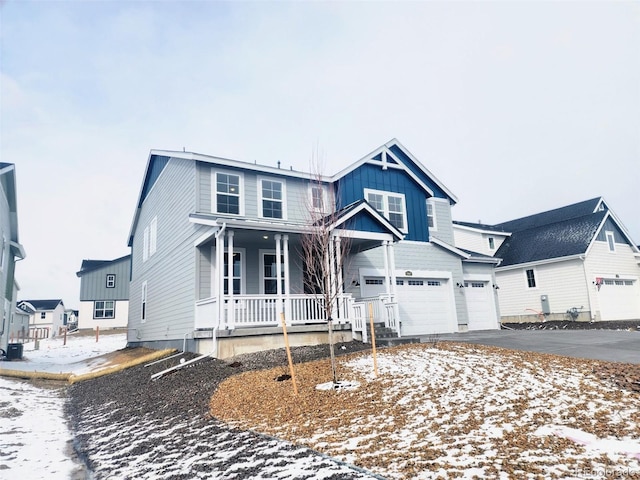 view of front of house featuring aphalt driveway, board and batten siding, a garage, and a porch