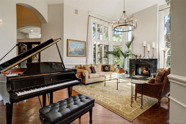 sitting room with a notable chandelier, a premium fireplace, and dark hardwood / wood-style flooring