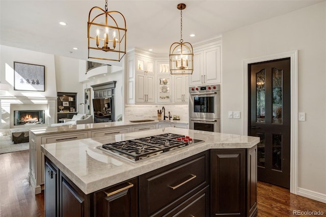 kitchen featuring appliances with stainless steel finishes, white cabinetry, dark hardwood / wood-style flooring, and a center island