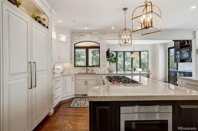 kitchen featuring light stone counters, sink, and a kitchen island