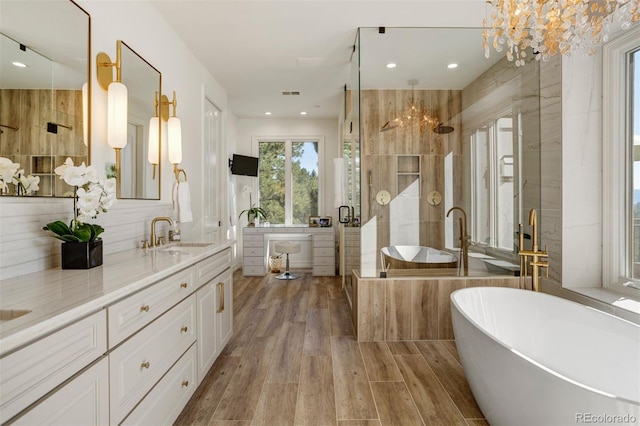 bathroom featuring hardwood / wood-style floors, vanity, separate shower and tub, and a chandelier