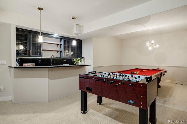 rec room featuring indoor wet bar, an inviting chandelier, and light carpet