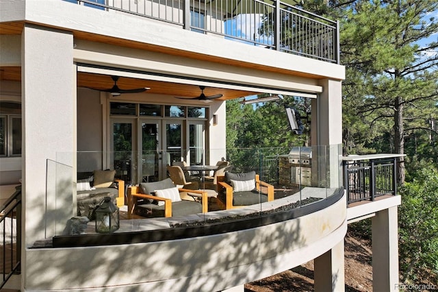 view of patio / terrace featuring a balcony, an outdoor hangout area, ceiling fan, and french doors