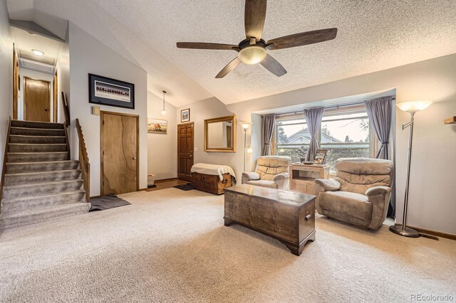 carpeted living area with lofted ceiling, a textured ceiling, stairs, ceiling fan, and baseboards