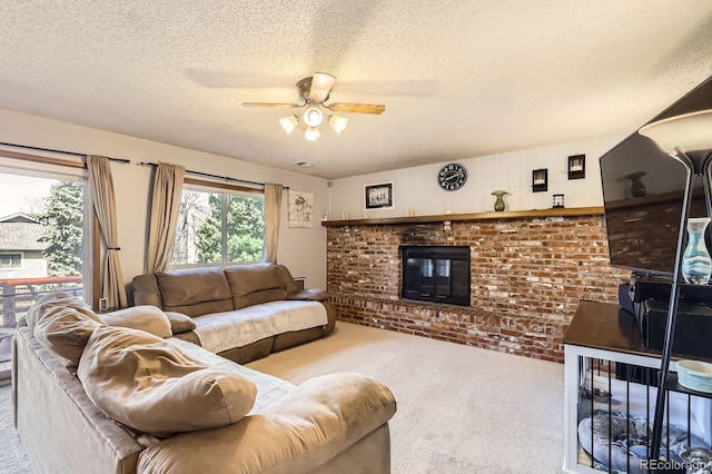 carpeted living room with a textured ceiling, ceiling fan, a brick fireplace, and brick wall
