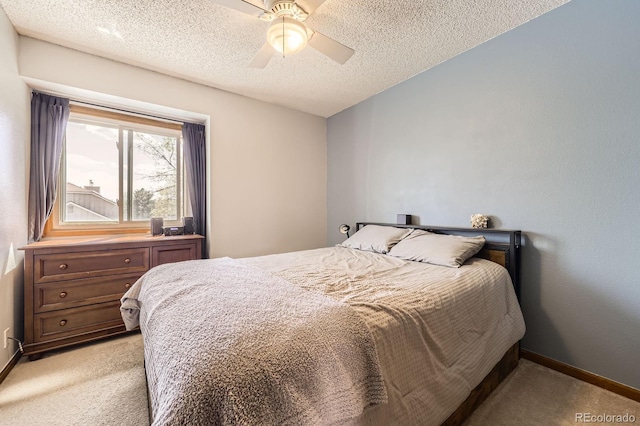 bedroom featuring light carpet, baseboards, a textured ceiling, and ceiling fan