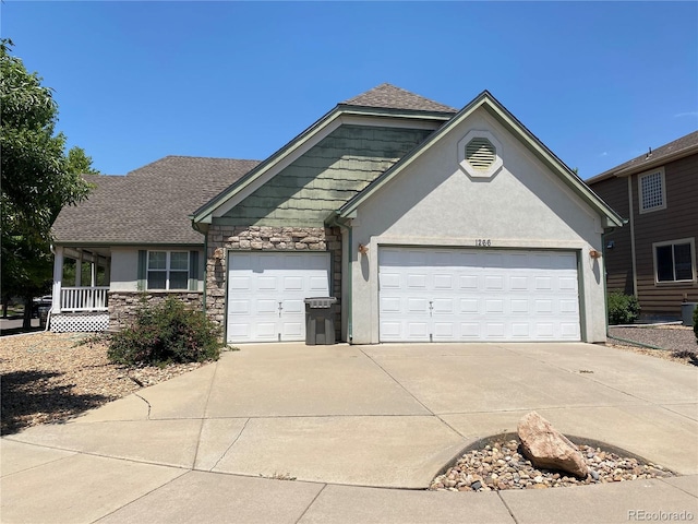 view of front of property featuring an attached garage, driveway, stucco siding, and stone siding