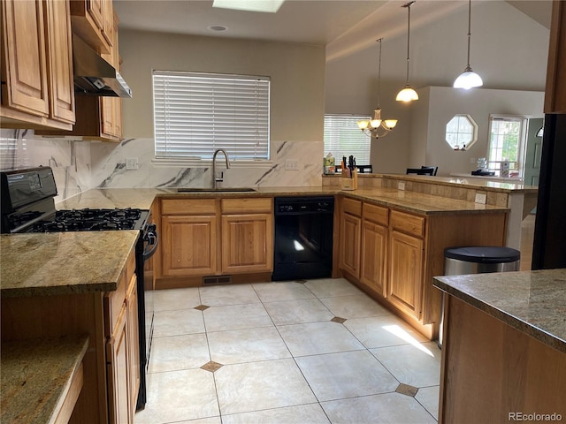 kitchen featuring dark stone countertops, a peninsula, black appliances, decorative backsplash, and a sink