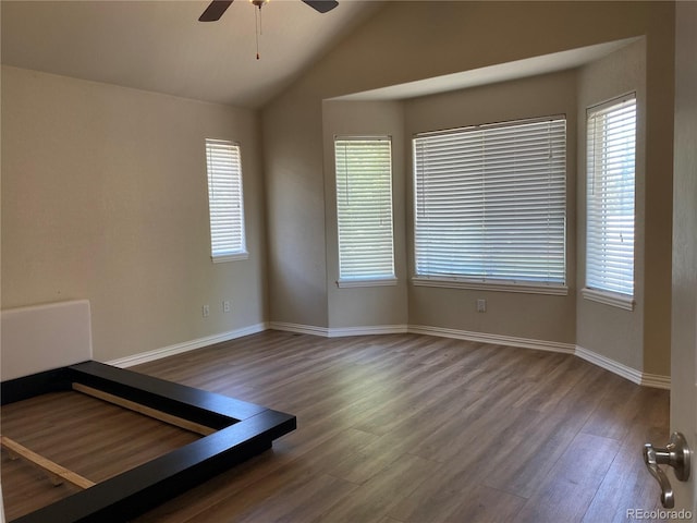 unfurnished room featuring ceiling fan, vaulted ceiling, wood finished floors, and baseboards