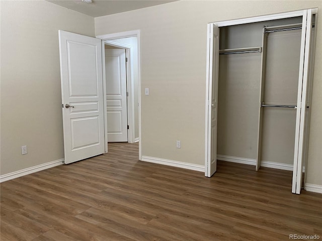 unfurnished bedroom featuring a closet, baseboards, and wood finished floors