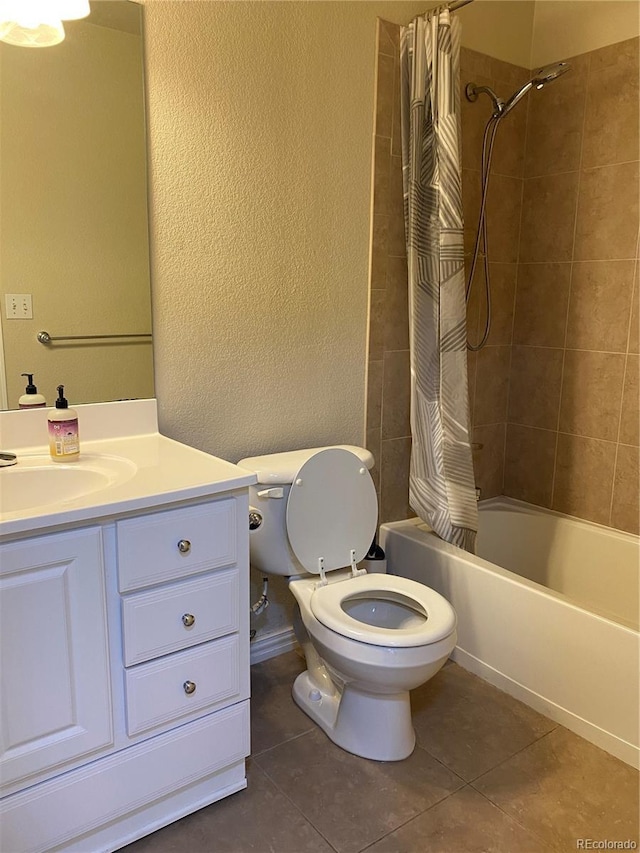 full bath featuring toilet, a textured wall, shower / bathtub combination with curtain, vanity, and tile patterned floors