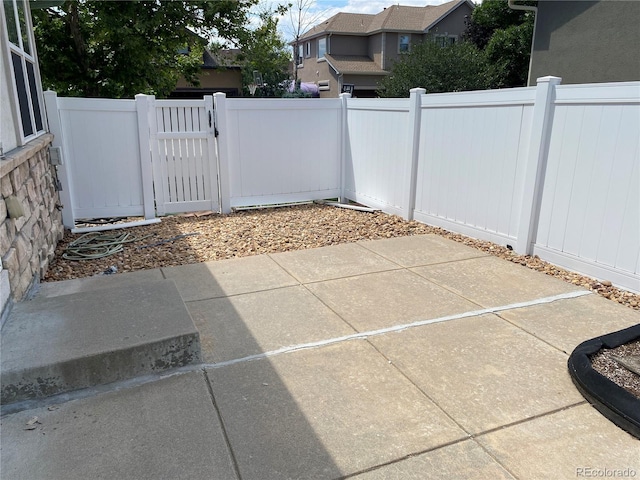 view of patio featuring fence and a gate