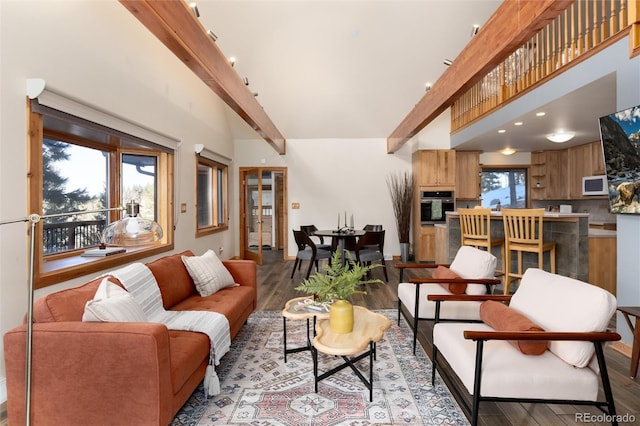 living room with beamed ceiling, wood-type flooring, and a towering ceiling