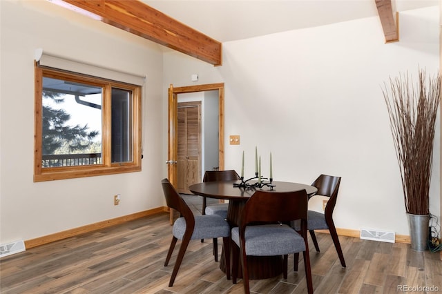 dining area with dark hardwood / wood-style flooring and beamed ceiling