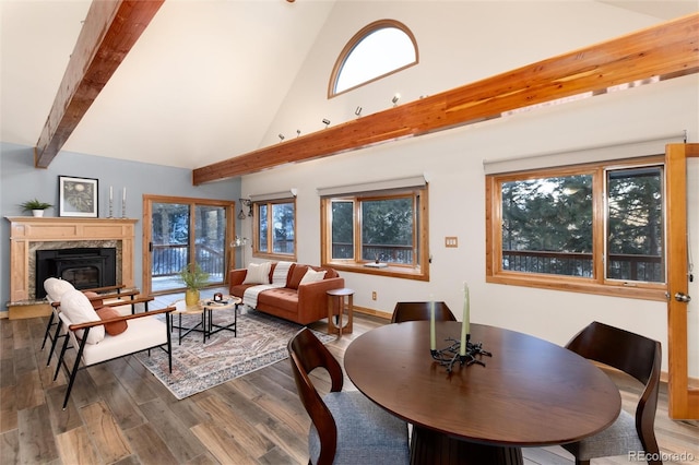 dining room featuring beamed ceiling, a healthy amount of sunlight, high vaulted ceiling, and hardwood / wood-style flooring