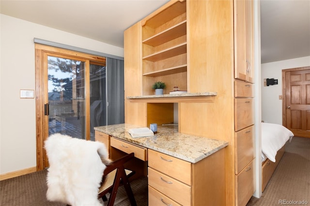 carpeted office featuring built in desk