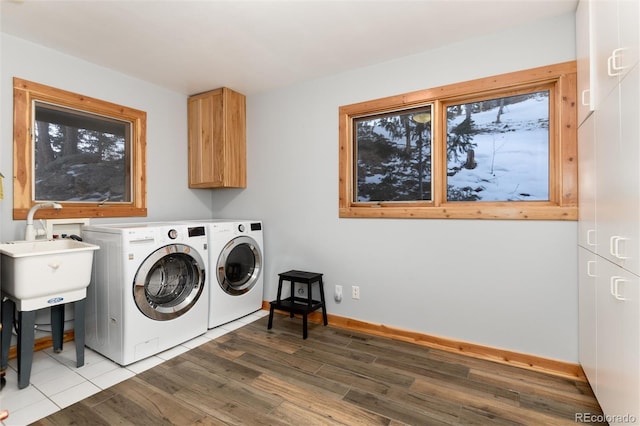 laundry area featuring cabinets, dark wood-type flooring, sink, and independent washer and dryer